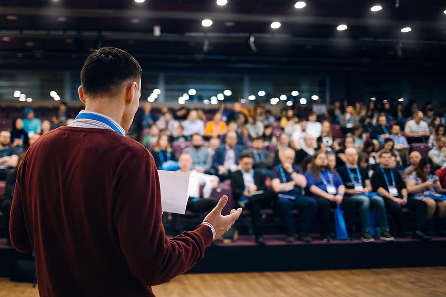 Event Insurance - Business Conference with a Man on Stage Talking About Performance