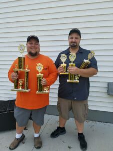 Dan Barnum and a friend holding up the trophies they won from a cooking competition.