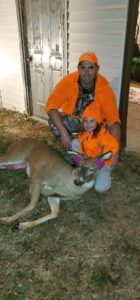 Jason Phillips holding a dead buck he shot with his daughter.