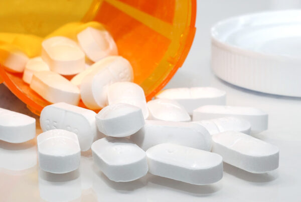 White Prescription Pills Spilling From Orange Pill Bottle