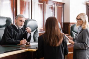 Judge discussing professional liability case with business attorney and her assistant.