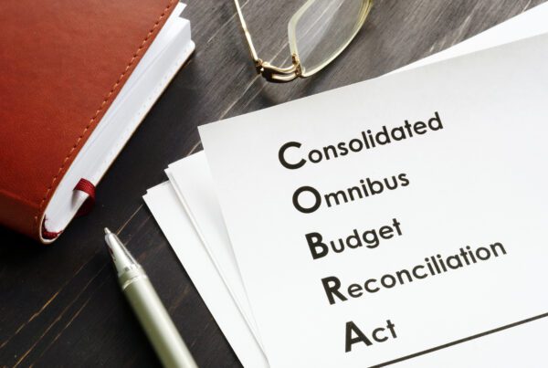 COBRA (Consolidated Omnibus Budget Reconciliation Act) written on white piece of paper on a desk.