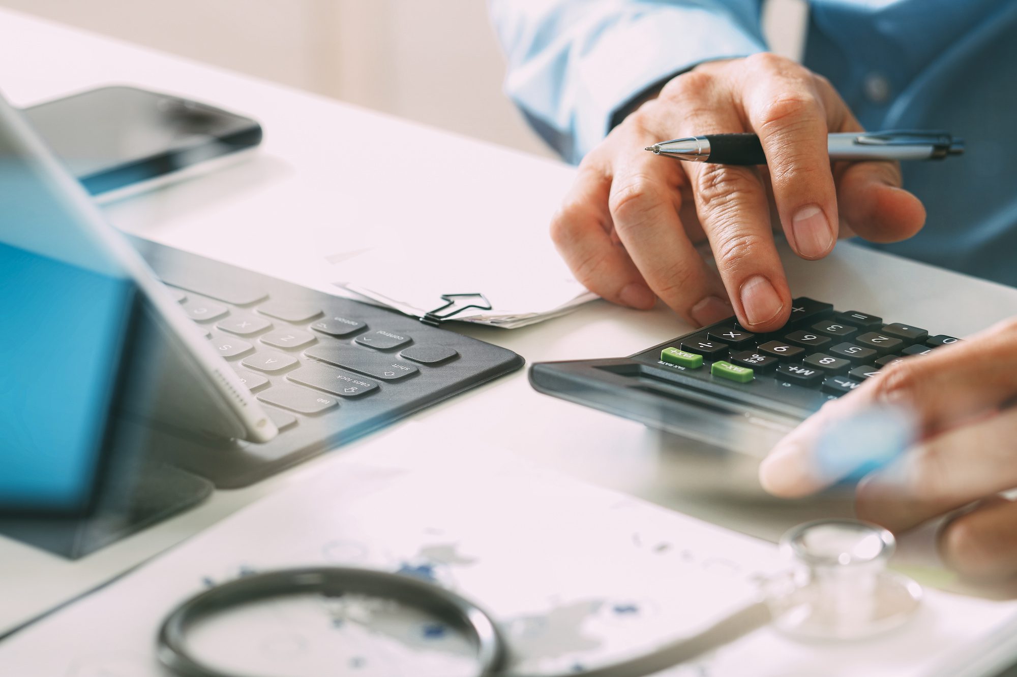 Close up of employer calculating PCORI fees on a calculator.