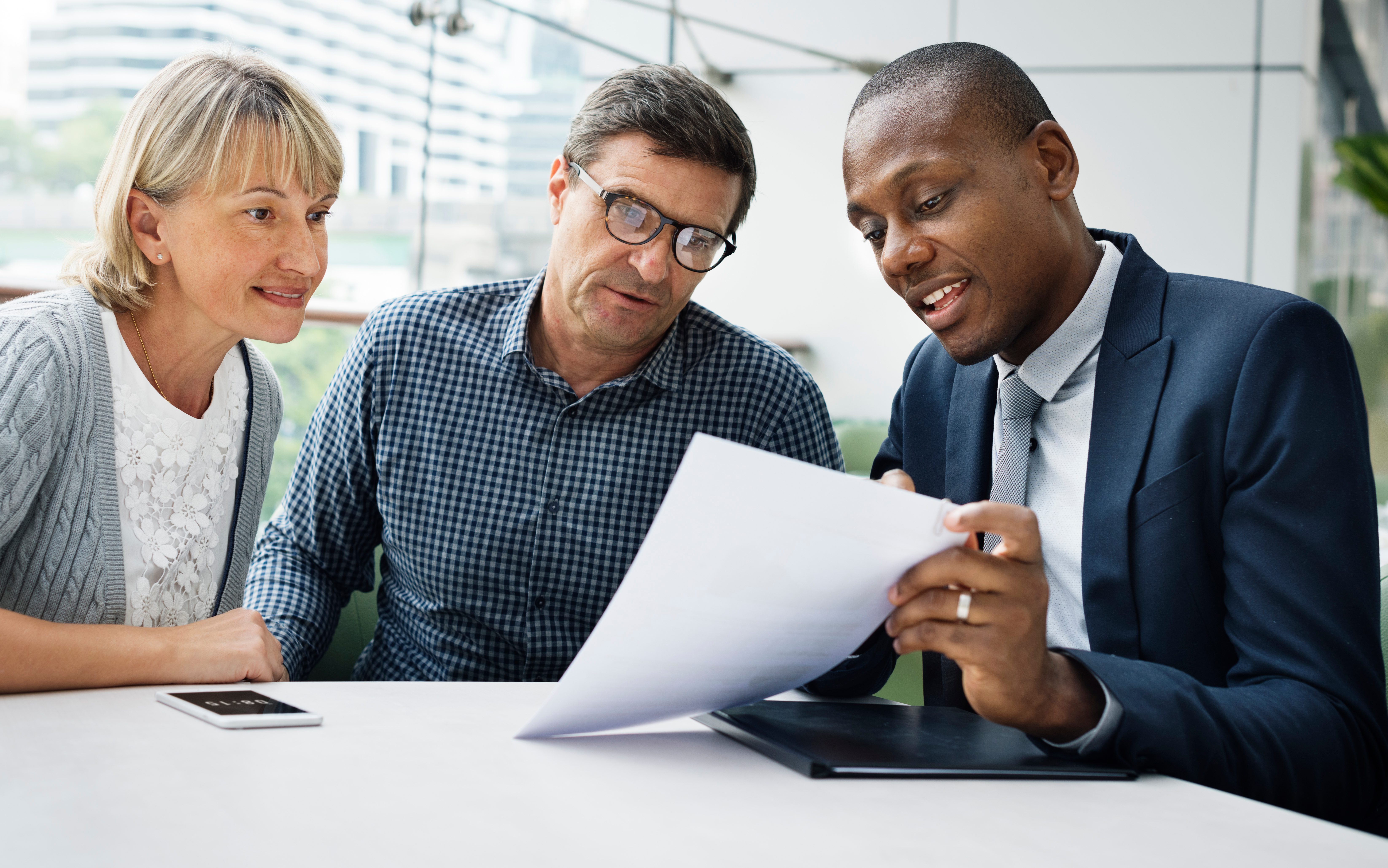 Black Wisconsin insurance agent helping an older couple with their insurance.