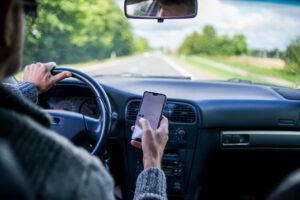 Man texting and emailing while driving his car down the highway.