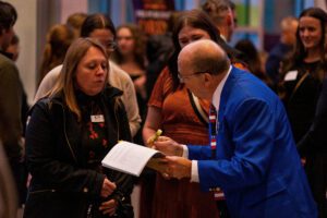 Wally Wheeler, Employee Benefits Specialist for Midwest Select, seen helping guests at the Eau Claire Chamber's 2024 Annual Meeting, "Eau What A Night."